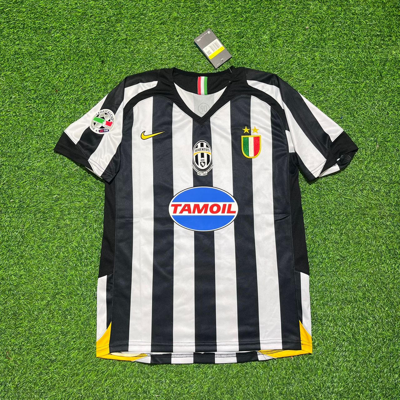 Black and white striped soccer jersey with brand logos on a green grass background