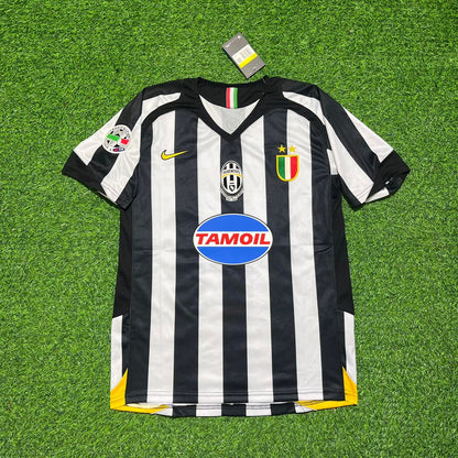 Black and white striped soccer jersey with brand logos on a green grass background
