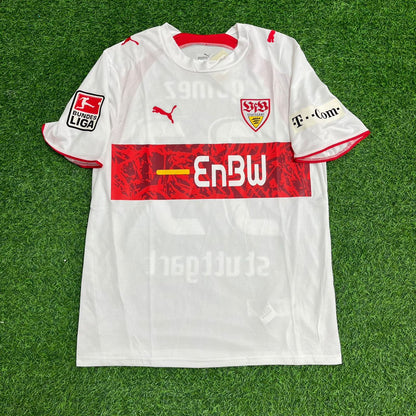 White sports jersey with red and black details on a green grass background